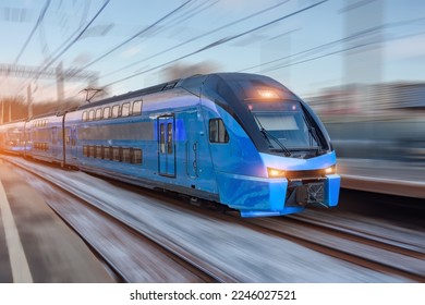 Electric passenger train drives at high speed among urban passenger station - Powered by Shutterstock