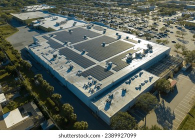 Electric photovoltaic solar panels installed on shopping mall building rooftop for production of green ecological electricity. Concept of producing sustainable energy