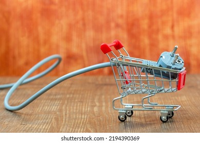 Electric Plug In Small Shopping Trolley. Energy Business Concept. Increasing Of Electricity Cost For Residential Customers And Business Users.