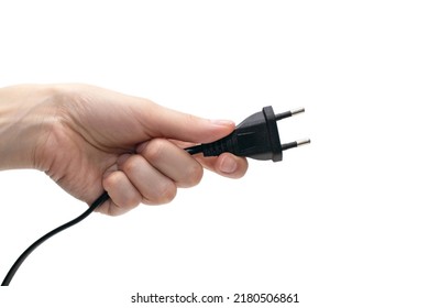 Electric plug for a socket in a hand on a white background. The concept of electricity and its importance in everyday life. Electric plug without a socket in a human hand. Power plug for the device