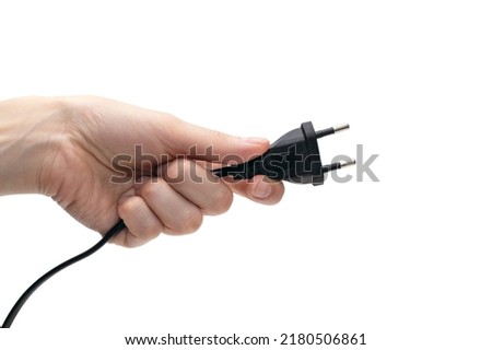 Electric plug for a socket in a hand on a white background. The concept of electricity and its importance in everyday life. Electric plug without a socket in a human hand. Power plug for the device