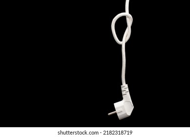 Electric Plug For A Socket With A Knot On A Cable On A Black Background With Free Space For Text. The Concept Of The Inability To Get Energy Or Electricity. No Access To Electricity Or Power Outages