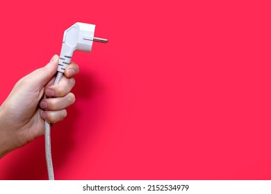 Electric plug for a socket on a red background. The concept of electricity and its importance in everyday life. Electric plug without socket. Free space for text