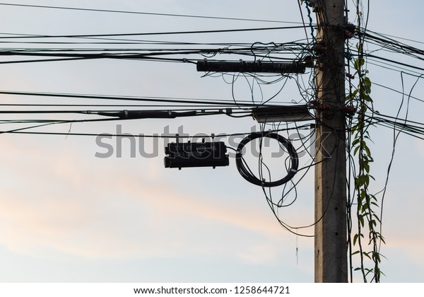 Electric pole\
and Sky. Power lines in field on sunrise background. Silhouettes of\
poles with wires at\
dawn.