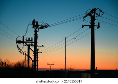 Electric poles with power lines at sunset. Electricity transmission. - Shutterstock ID 2143155817
