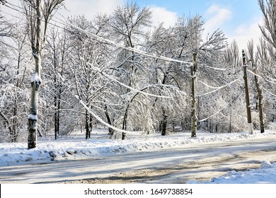 Electric Power Line Hanging Down Under The Weight Of Snow. Weather Collapse. Snow On Electrical Wires In The City. Old Electrical Cables.