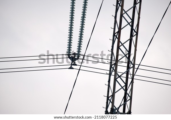 Electric power lines divided by safe guard\
insulating frame transfening safely high voltage electrical energy\
through cable wires. Electricity transmission on long distance\
concept
