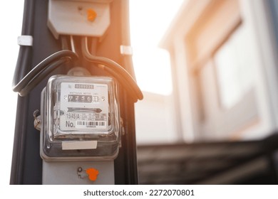 Electric power meter measuring power usage. Watt hour electric meter measurement tool at pole, outdoor electricity for use in home appliance monitor the home's electrical energy consumption. - Shutterstock ID 2272070801