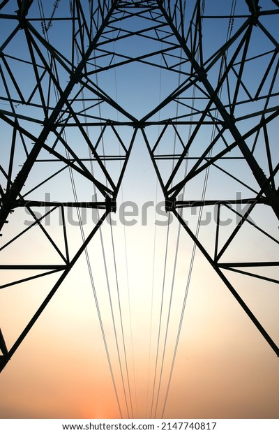 Electric power transmission lines.\
High voltage post. Industrial landscape. Electricity pylon at\
sunset sky on the background. Electric distribution\
station