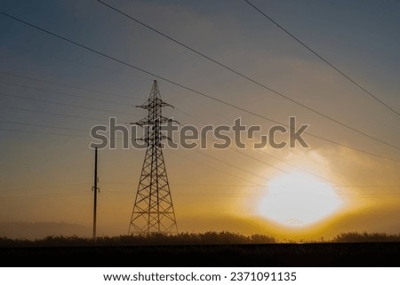 Electric pylon in the Estonian countryside covered in fog and smog shortly after the dawn of a new day, Metsanurme, Estonia