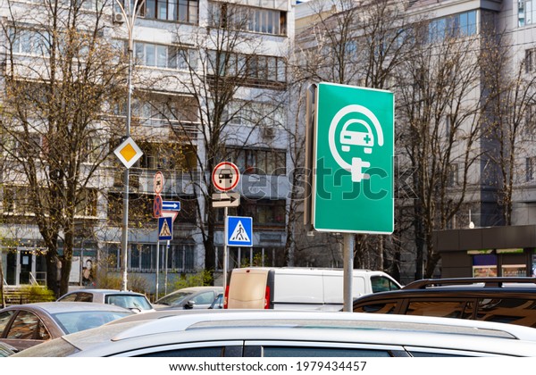 Electric\
recharging point for electric cars - road sign. charging station\
road sign among the cars on the\
street\
