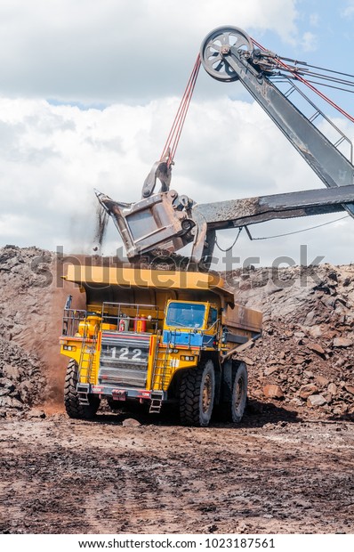 Electric rope shovels loading of coal, ore on\
the dump truck. The big dump truck is mining machinery, or mining\
equipment to transport coal from open-pit or open-cast mine as the\
Coal Production.
