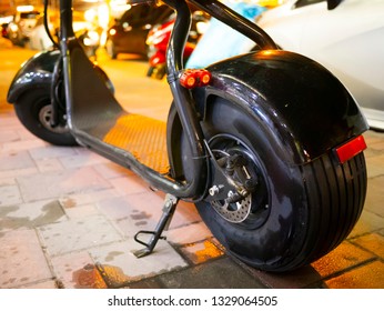 Electric Scooter On The Sidewalk At Night