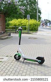 electric scooter  stand on the bandwagon on the street. Sunny summer day. Modern city transport.  - Shutterstock ID 2155800121