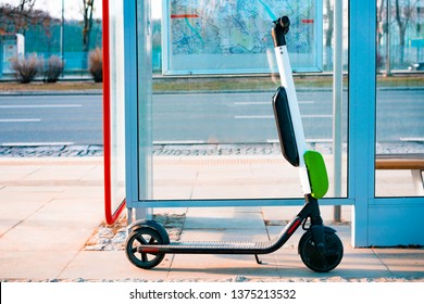 Electric scooter stands near public bus stop. Electric scooters stand along the streets of downtown. The public scooters are available to rent as a means of transportation throughout the city