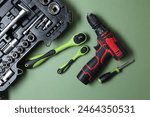 Electric screwdriver and accessories on pale green background, flat lay