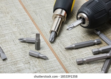 electric screwdriver, self-tapping screws, screwdriver bits, tool box on a wooden background