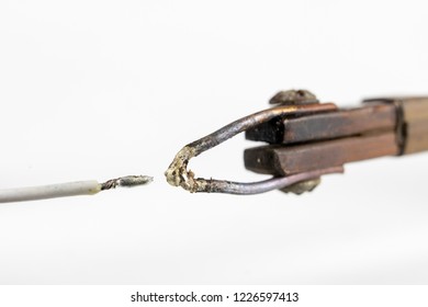 Electric Soldering Iron Finished With A Copper Arrowhead. Accessories For Electronics On A White Table. Light Background.