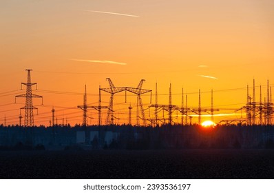 Electric substation silhouette and power lines against beautiful evening sky at sunset
