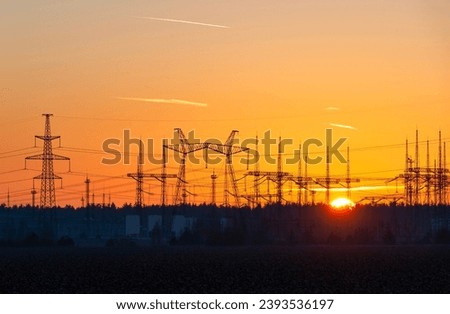 Electric substation silhouette and power lines against beautiful evening sky at sunset
