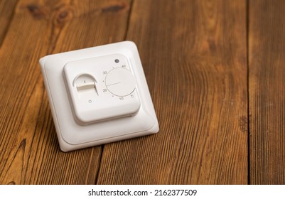Electric Thermostat For Underfloor Heating On A Wooden Background, Close-up.