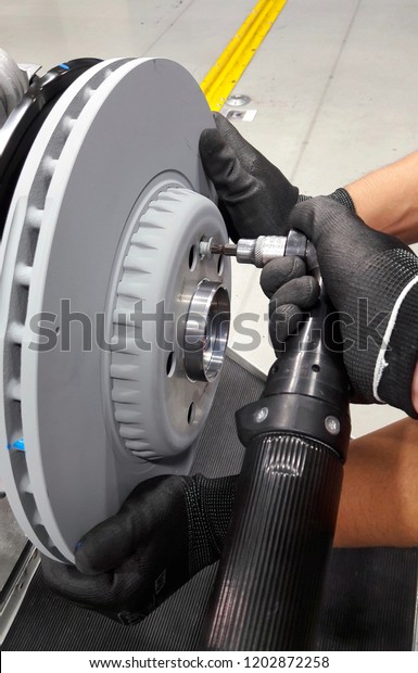 Electric tool tightening the bolt to lock\
in the brake disc for process assembly\
line.
