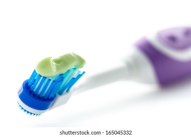 Electric toothbrush with toothpaste isolated on white background