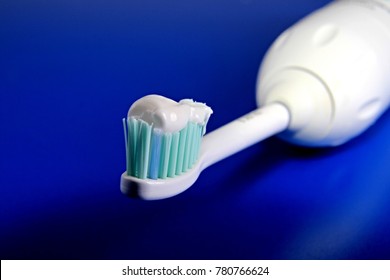 Electric Toothbrush And Toothpaste Sitting On A Blue Table No People Stock Photo