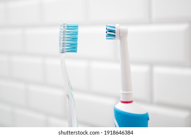 An electric toothbrush versus a regular toothbrush. - Shutterstock ID 1918646384