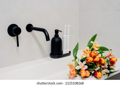 Electric Toothbrushes On A Black Stand With A Black Soap Dispenser In The Bathroom