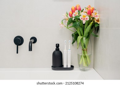 Electric Toothbrushes On A Black Stand With A Black Soap Dispenser In The Bathroom