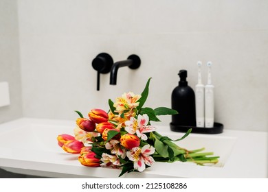 Electric Toothbrushes On A Black Stand With A Black Soap Dispenser In The Bathroom