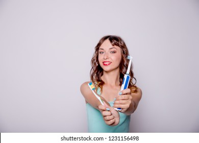 electric and traditional toothbrush.Hygiene of the oral cavity. A young beautiful woman chooses between an electric and a simple toothbrush.Happy smiling woman Brushing healthy teeth with tooth brush.