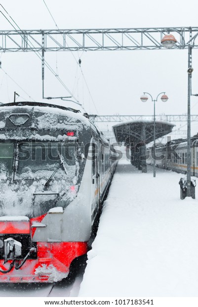 Electric\
train in snow in a blizzard on an empty\
platform
