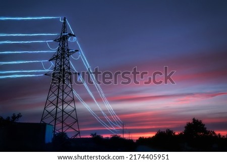 Electric transmission towers with glowing wires against the sunset sky background. High voltage electrical pylons. Energy concept.
