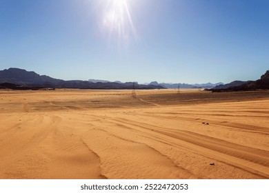 Electric transmission towers stretch across the Jordanian desert landscape, connecting distant regions through the arid, expansive terrain, with rugged mountains in the background - Powered by Shutterstock