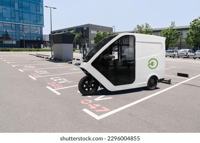 Electric tricycle scooter with charging station on a parking lot for LEV - light electric vehicles