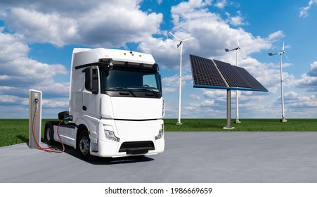 Electric Truck With Charging Station On A Background Of Solar Panels And Wind Turbines. Concept