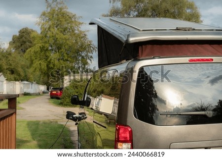 Electric van campervan plugged in traction battery on charge solar panel on raised roof charging leisure battery
