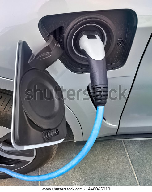 Electric vehicle being plugged\
in