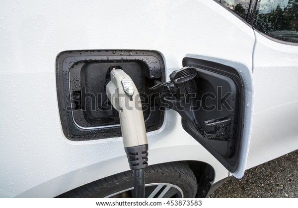 Electric\
vehicle charging. Charging port of electric car. Charging an\
electric car with the power supply plugged\
in.