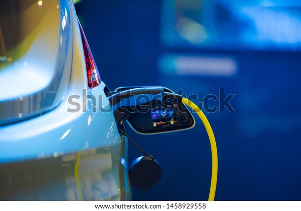 Electric vehicle\
charging port plugging in EV modern car. save ecology alternative\
energy sustainable of\
future