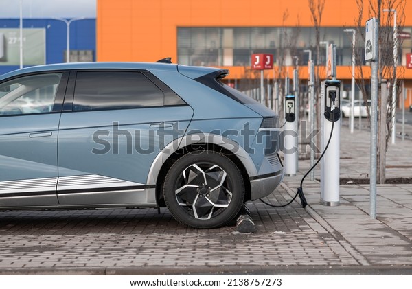 Electric\
vehicle charging at a station in parking\
lot