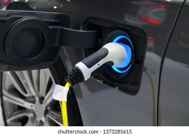 Electric Vehicle charging in station with power supply plugged into an electric car being charged. - Shutterstock ID 1373285615