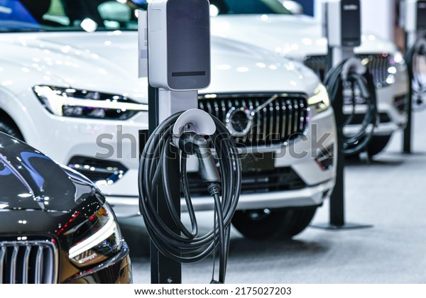 Electric Vehicle charging in\
station with power supply plugged into an electric car being\
charged	