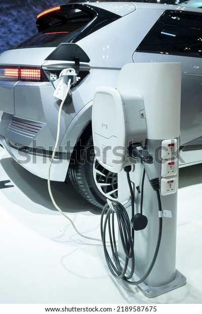 Electric vehicle\
at charging station with the power cable supply plugged in.\
Eco-friendly alternative energy\
concept.