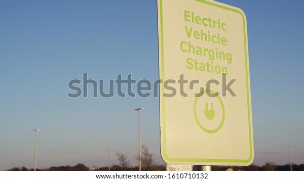 Electric vehicle\
charging station sign during sunset. Electric cars can get\
recharged at this simple to use station\
