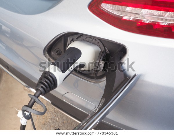 Electric\
Vehicle or EV car charging electric power in battery via EV\
charging socket and plug. Green energy\
concept.