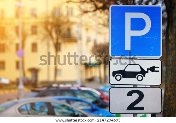 Electric vehicle parking sign, spots for electric\
car only. Parking signs for charge two electric cars on electricity\
filling station. Road sign at city street, electric vehicle\
charging station (EV)
