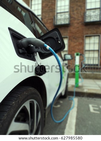 Electric vehicle plugged into a charging station on the street in Dublin, Ireland.